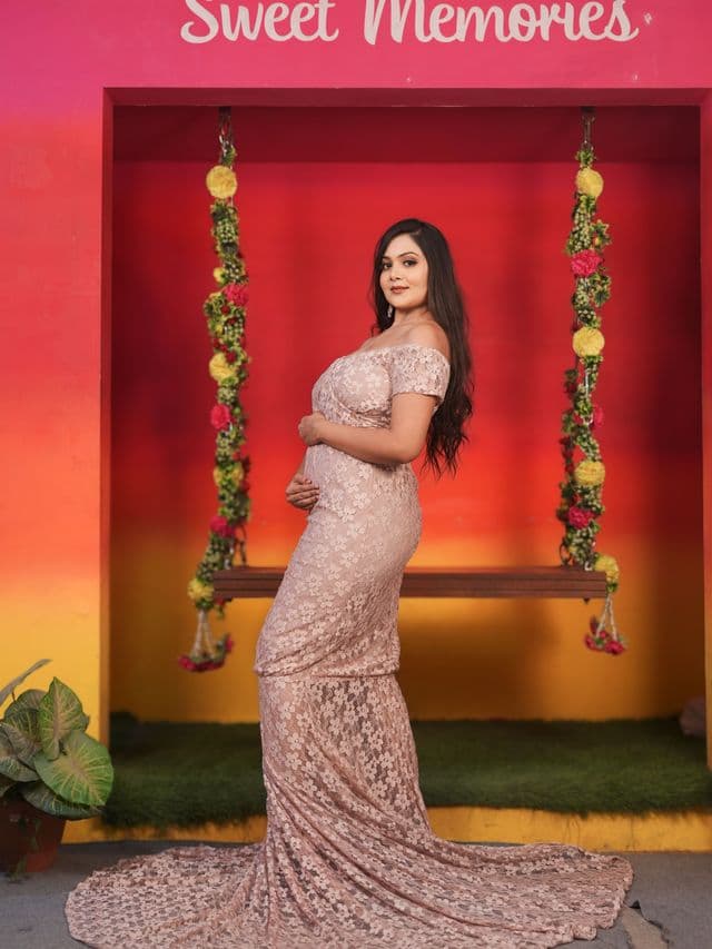blush elegance maternity gown on an expecting mom, studio portrait.
