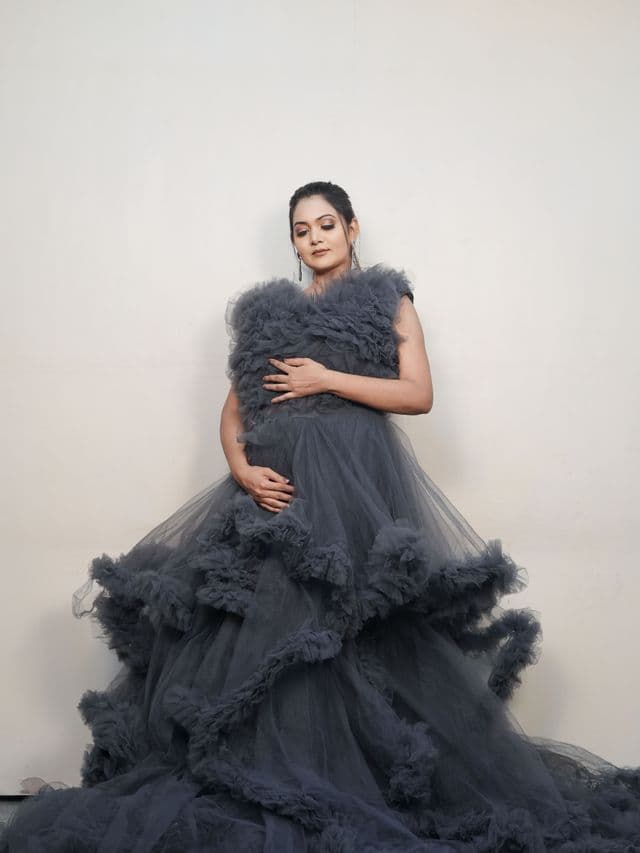versatile charcoal maternity gown on an expecting mom, studio portrait.